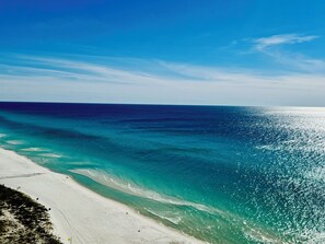 En strand med kristallklart, turkosfärgat vatten och vit sand.