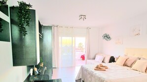 Habitación de hotel moderna con una cama, un escritorio con un tazón, un espejo y vistas al exterior.