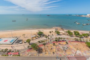A coastal area with a beach, a pier, and a road leading to a parking area. - Iracema Residence #103 - Seafront by Carpediem (Fortaleza)