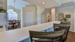 A modern kitchen with a long island, dining chairs, and a ceiling fan. - Perfect 3 Bedroom-3 Bath Condo / Gorgeous Views / Heart of Branson/ Affordable (Branson)