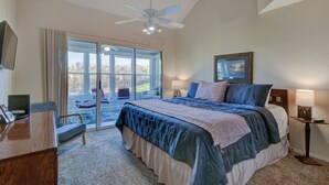 A bedroom with a large bed, a desk, a chair, a ceiling fan, and a view through a glass door. - Perfect 3 Bedroom-3 Bath Condo / Gorgeous Views / Heart of Branson/ Affordable (Branson)