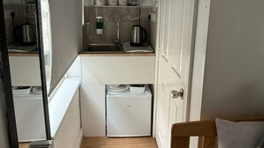 A compact kitchen with a microwave, kettle, and small refrigerator. - Family Bedroom with Attached Bathroom in Blackpool-Families and Couplies Only (Preston)