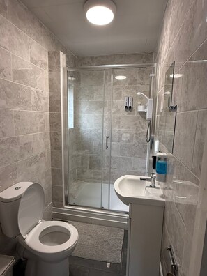 Een douche, een haardroger, handdoeken, toiletpapier