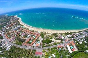 An aerial view of a coastal area with a beach, residential buildings, and a road. - Villa Dawn, Bahia de Arena (Cabarete)