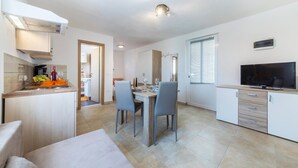 A modern kitchen with a dining area, a TV, and a sofa. - Lovely apartment in Trget (Trget)
