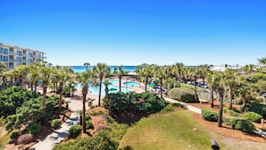 Ett semesterparadis med pool, palmer och utsikt över havet.