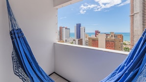 Varanda com vista para a paisagem urbana e o mar.