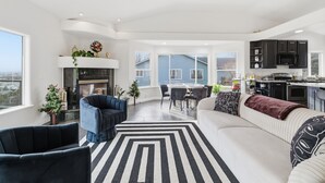 Een moderne woonkamer met een open haard, een eethoek en een keuken.