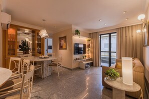 A modern living room with a dining area, a TV, and a large window. - Nautical #604 - Space and Comfort by Carpediem (Fortaleza)