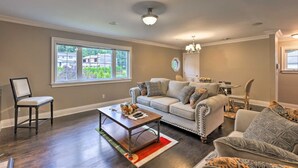 A living room with a sofa, armchairs, a coffee table, and a dining area with a table and chairs.