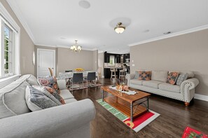Un salon comprenant un canapé, une table basse et un coin repas avec des chaises et une table.