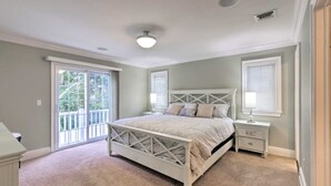 A bedroom with a bed, nightstands, a dresser, and a window with blinds.