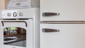 Cuina blanca amb forn integrat i dues noves pomes cromades a la porta.