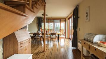 A wooden staircase leading to a dining area with a view of the outdoors.