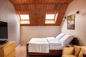 A bedroom with a wooden ceiling, a bed with white bedding, a TV on a wooden dresser, and a painting on the wall. - House with a View, Mucharz 405 (Mucharz)
