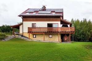 A two-story house with a balcony, solar panels, and a stone foundation. - House with a View, Mucharz 405 (Mucharz)