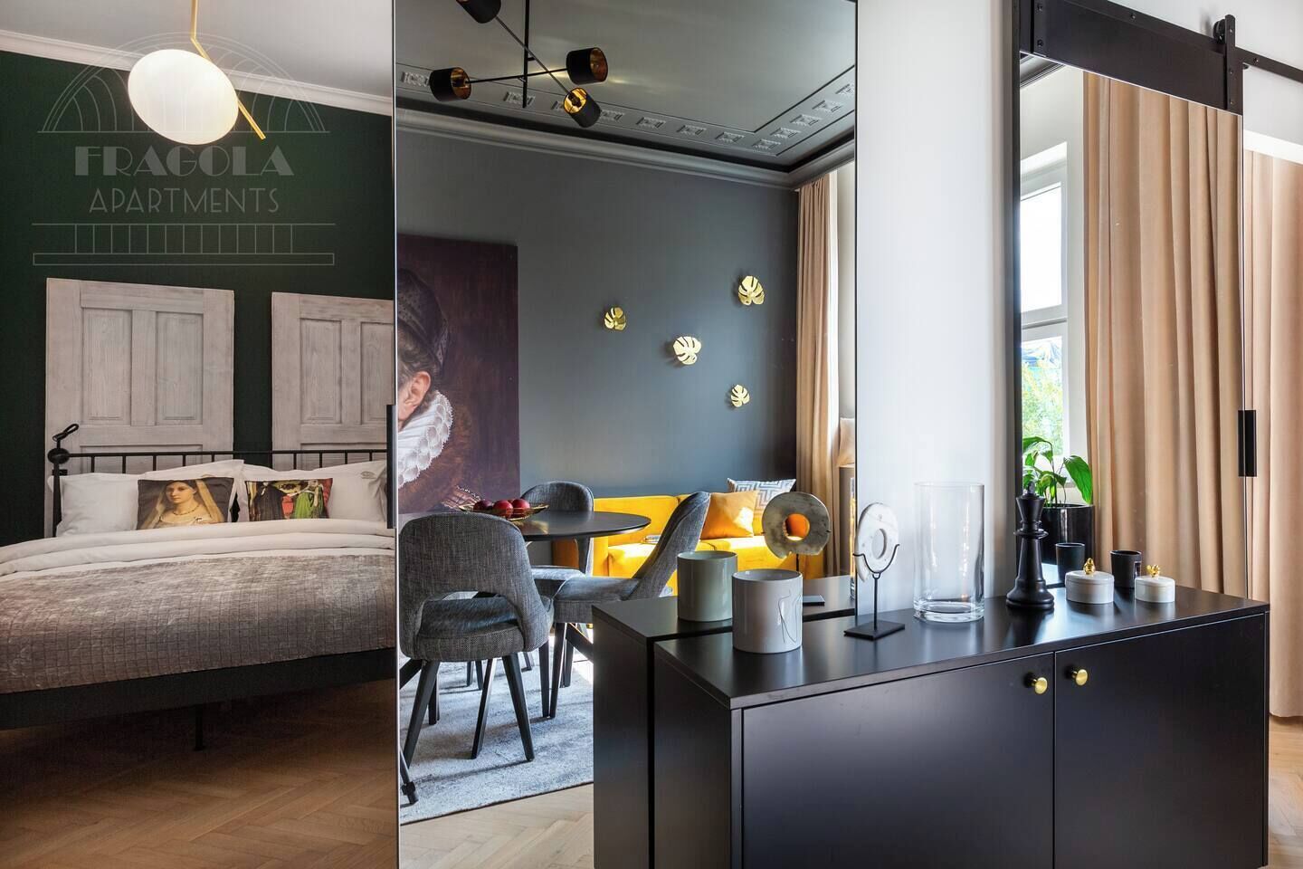 Ein Schlafzimmer mit Bett, Schreibtisch und Stuhl. An der Wand hängt ein Bild und auf dem Schreibtisch steht eine Pflanze.