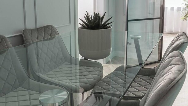 Ein modernes Interieur mit einem Glastisch, umgeben von gepolsterten Stühlen.