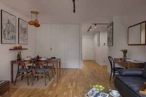 A modern living space with a dining area, a sofa, and a desk. - Cozy & Family-Friendly 2-bed Apartment (Kraków)