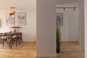 A dining area with a wooden table, chairs, and a hanging light fixture. - Cozy & Family-Friendly 2-bed Apartment (Kraków)
