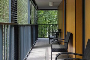 A balcony with metal railings, a table, and two chairs. - Modern 2-Bed Apartment with 2 Bathrooms, Balcony (Kraków)