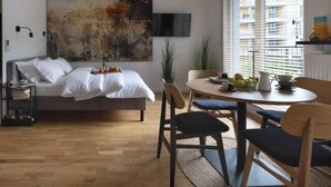 Una camera da letto moderna con un letto, un comodino e un'area pranzo con sedie e tavolo.