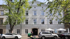 A building with a symmetrical facade, multiple windows, and a central entrance. - Canvas House Porcelain 2-bed family apartment (Kraków)
