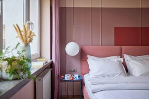 A bedroom with a bed, bedside table, and a window with curtains. - Polka Apartment 2-bed (Kraków)