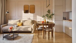 Een moderne woonkamer met een bank, salontafel en een eettafel.