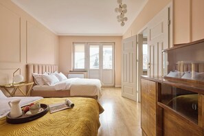A hotel room with a bed, bedside table, and a dresser. - Polka Apartment 2-bed (Kraków)