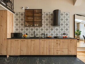 Eine moderne Küche mit Holzausstattung, schwarzer Arbeitsplatte und einer gefliesten Spritzschutzwand.