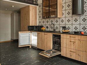A kitchen with wooden cabinets, a built-in dishwasher, a microwave, and a window above the sink. - Art Palace 58m apartment with mezzanine (Kraków)