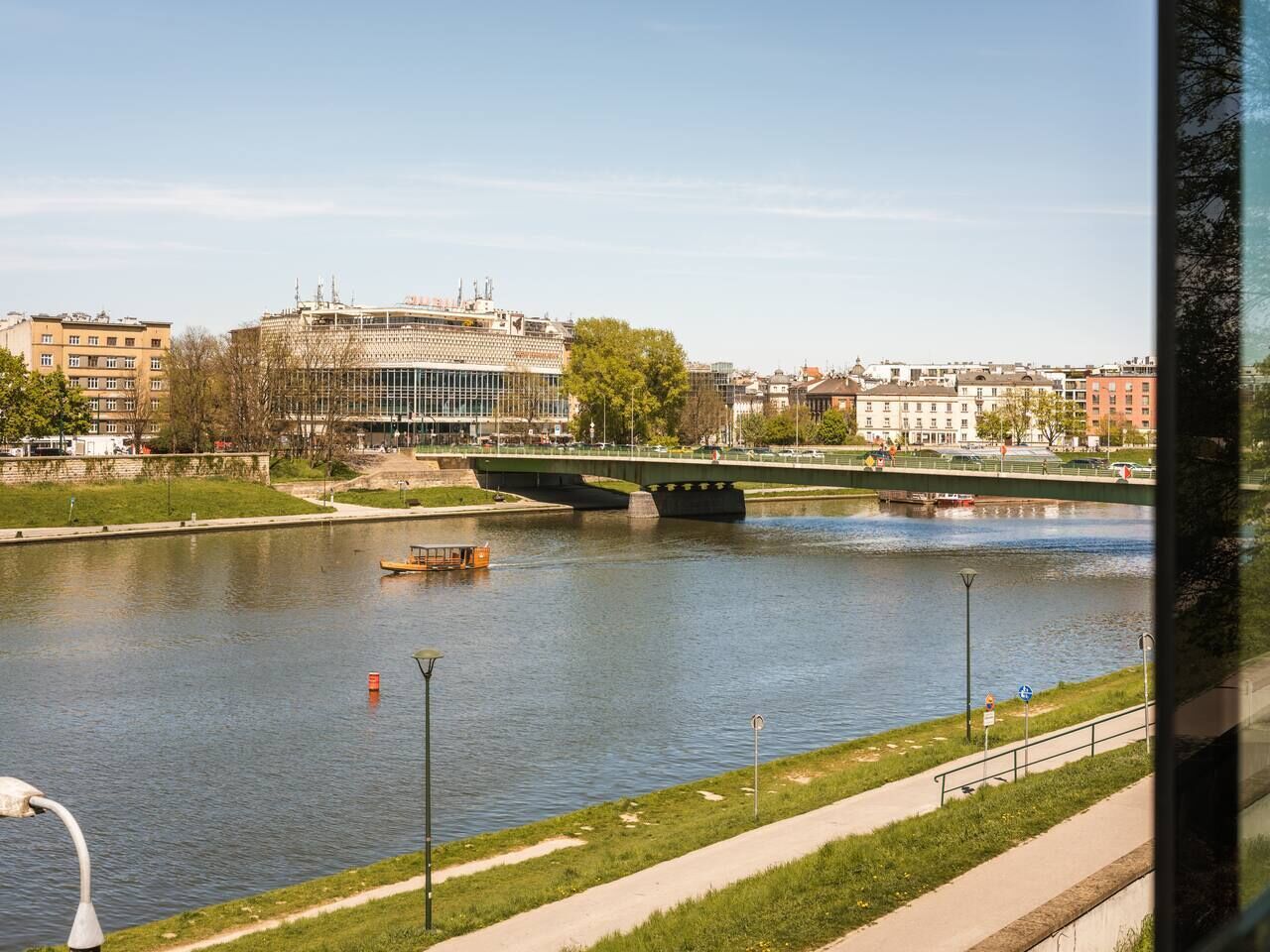 A river with a bridge, buildings, and a boat.