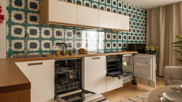 Una cocina compacta con lavavajillas, horno y una pequeña zona de encimera.