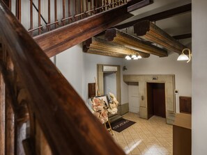 A wooden staircase with a decorative ceiling and a door labeled '2' leading to a room with a mirror, a framed picture, and a doormat. - Main Square spacious 1-bed with bathtub (Kraków)