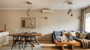 Ein modernes Wohnzimmer mit Esstisch, Sofa und Couchtisch.
