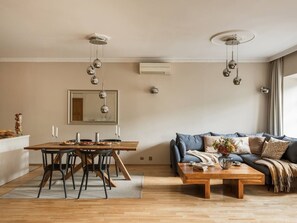 A modern living room with a dining table, sofa, and coffee table. - Main Square spacious 1-bed with bathtub (Kraków)