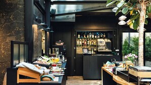 A modern kitchen with a bar area, wooden countertops, and a variety of food and drink items. - White Lotus - penthouse with roof terrace (Kraków)