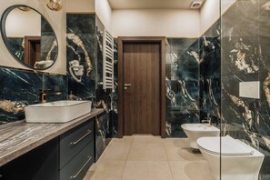 A modern bathroom with a marble vanity, a toilet, and a shower area. - White Lotus - 2-bedroom, living room (Kraków)
