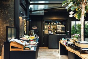 A modern kitchen with a bar area, wooden countertops, and a variety of food and drink items. - White Lotus - 2-bed apartment, full kitchen (Kraków)