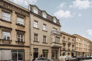 A multi-story building with a ground-floor shop named 'zabka.' - White Lotus - 2-bed apartment, full kitchen (Kraków)