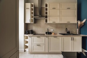 A modern kitchen with built-in cabinets, a countertop, and a sink. - White Lotus - 2-bed apartment, full kitchen (Kraków)