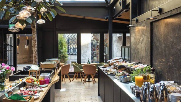 Un comedor moderno con una barra larga, diferentes alimentos y asientos.