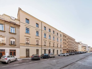 A row of multi-story buildings with parked cars on the street. - Green Boho 2-bed family apt in the city center (Kraków)