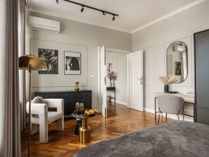 A modern bedroom with a large bed, a desk, a chair, a dresser, and a mirror. - Iconic Sunset Penthouse 115 sqm (Kraków)