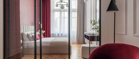 Un dormitorio con una cama, un escritorio, una silla y un sillón rojo.
