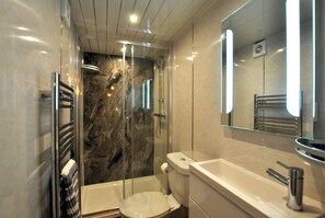 A modern bathroom with a glass-enclosed shower, a white toilet, and a large sink with a mirror above it. - Sma' Gift- Seafront sanctuary in ST Monans (Saint Monans)