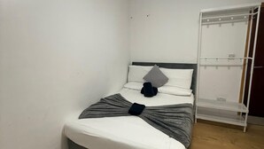 A neatly arranged bedroom with a bed, a bedside table, and a wardrobe. - Double Bedroom with Attached Bathroom in Blackpool-Families and Couplies Only (Blackpool)