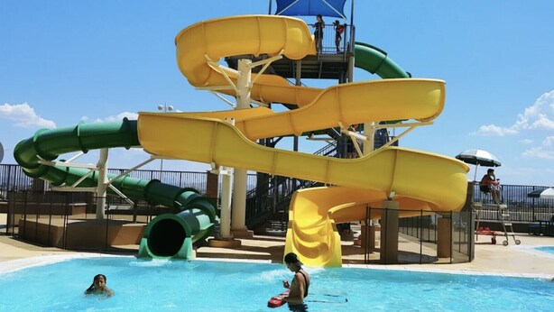 Un parque acuático con múltiples toboganes y una piscina.