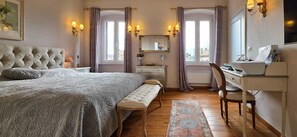 Une chambre à coucher avec un grand lit, un bureau et une chaise.